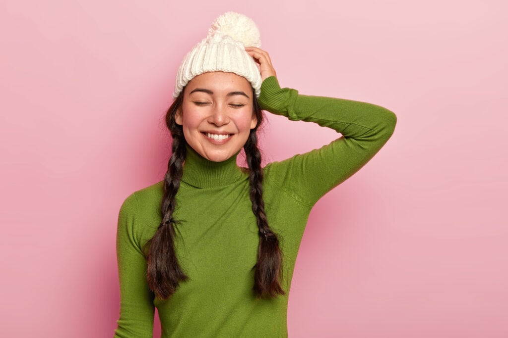 Devojka sa pletenicama nosi toplu zimsku kapu